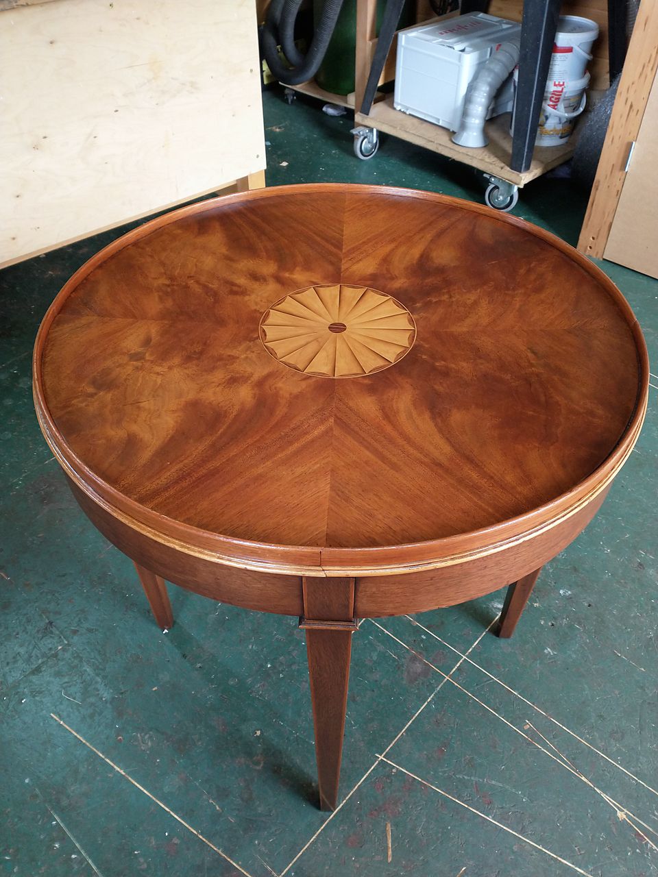 Round table with a sunburst-matched figured veneer top and an inlaid fan patera in the centre, freshly polished